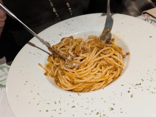 Spaghetti bolognese twirled onto a fork.